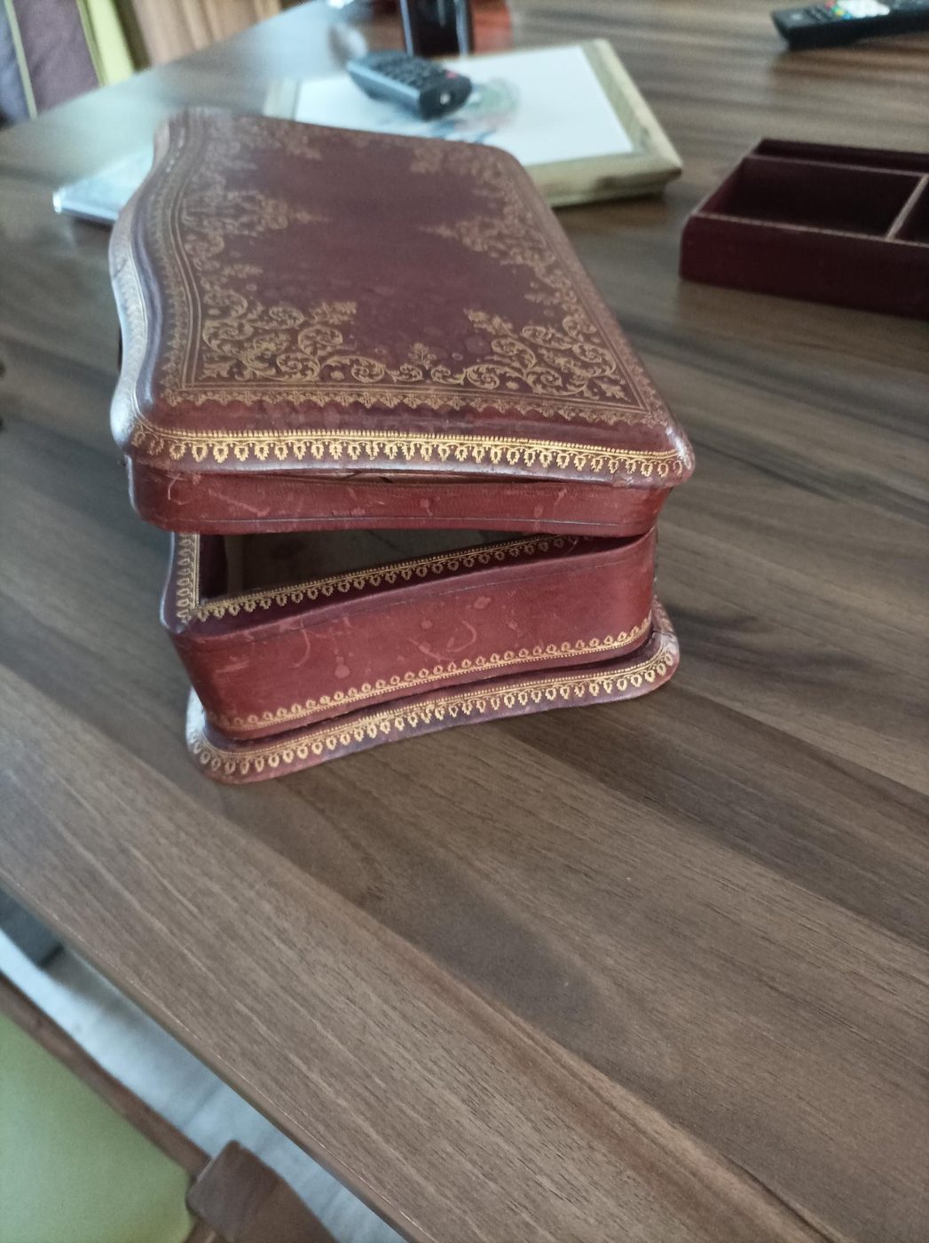 Coffret ancien entrouvert avant restauration, forme galbée et frises dorées usées